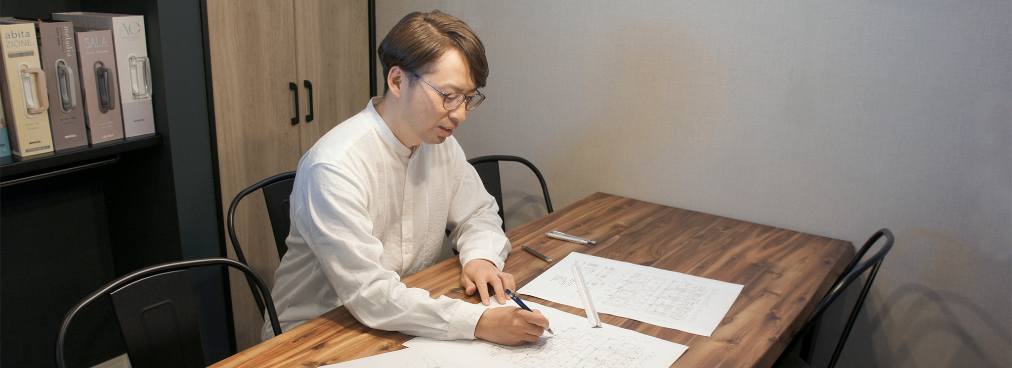 建築図面に書き込む手元。